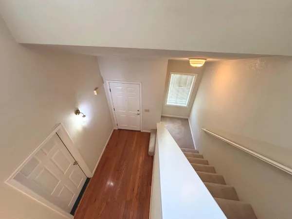 a view of a hallway with wooden floor and staircase