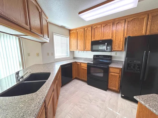 a kitchen with granite countertop a refrigerator and a sink