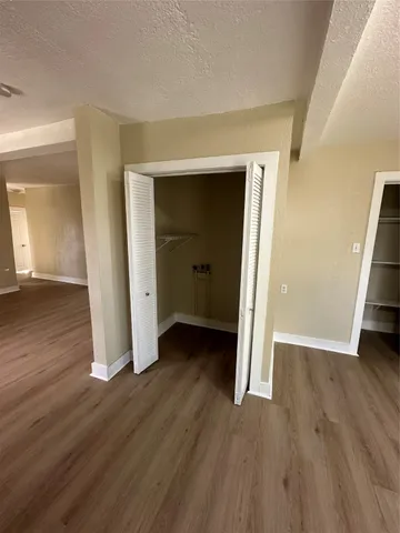an empty room with wooden floor and closet