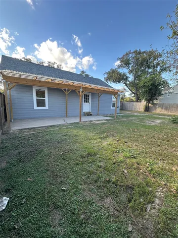 a view of a yard in front of a house with a large tree