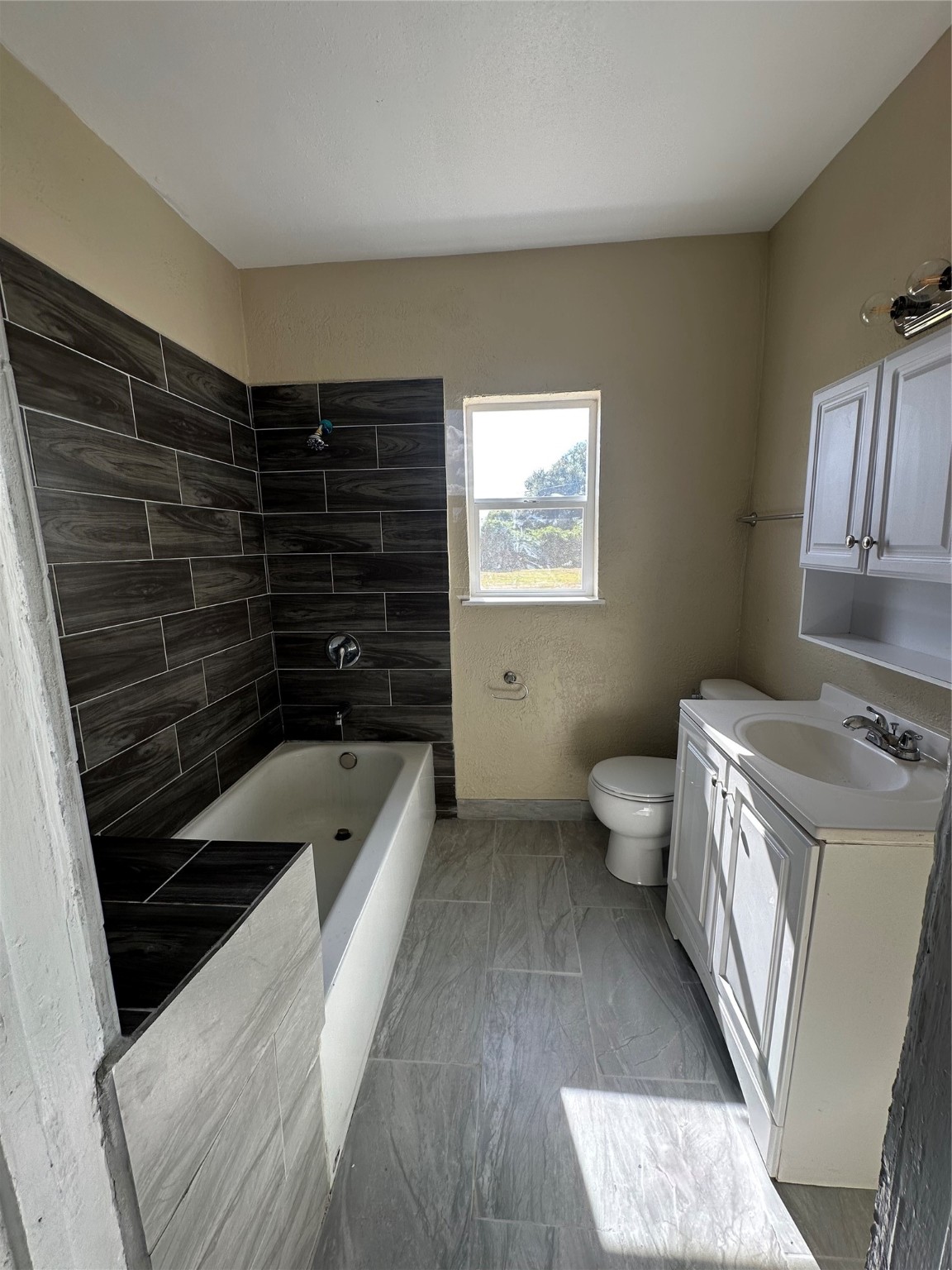 1411 Miles Street Houston, TX 77015 - Photo 9 of 14 a bathroom with a granite countertop sink a toilet and bathtub