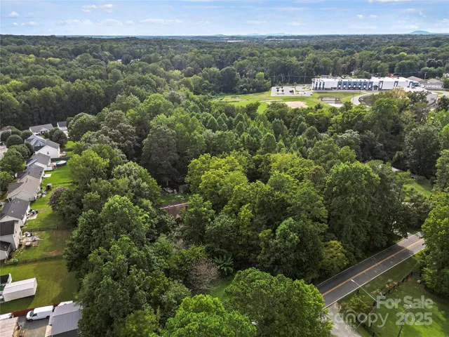 an aerial view of residential houses with outdoor space and trees