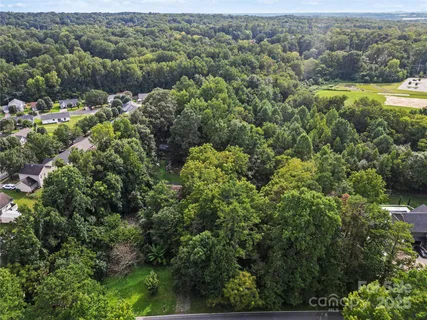 an aerial view of residential houses with outdoor space and trees