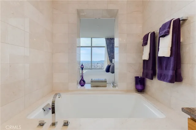 a bathroom with a tub sink and a mirror