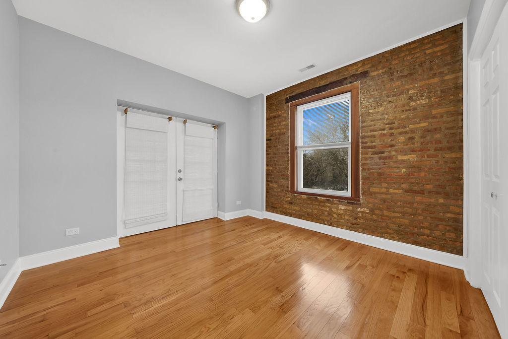 2256 West Arthur Avenue, Unit 2 Chicago, IL 60645 - Photo 11 of 17 a view of an empty room with wooden floor and a window