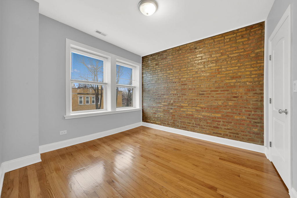2256 West Arthur Avenue, Unit 2 Chicago, IL 60645 - Photo 14 of 17 a view of an empty room with wooden floor and a window