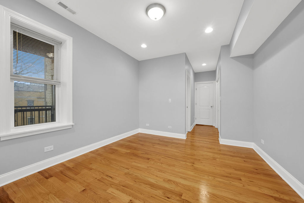 2256 West Arthur Avenue, Unit 2 Chicago, IL 60645 - Photo 9 of 17 a view of empty room with wooden floor and fan