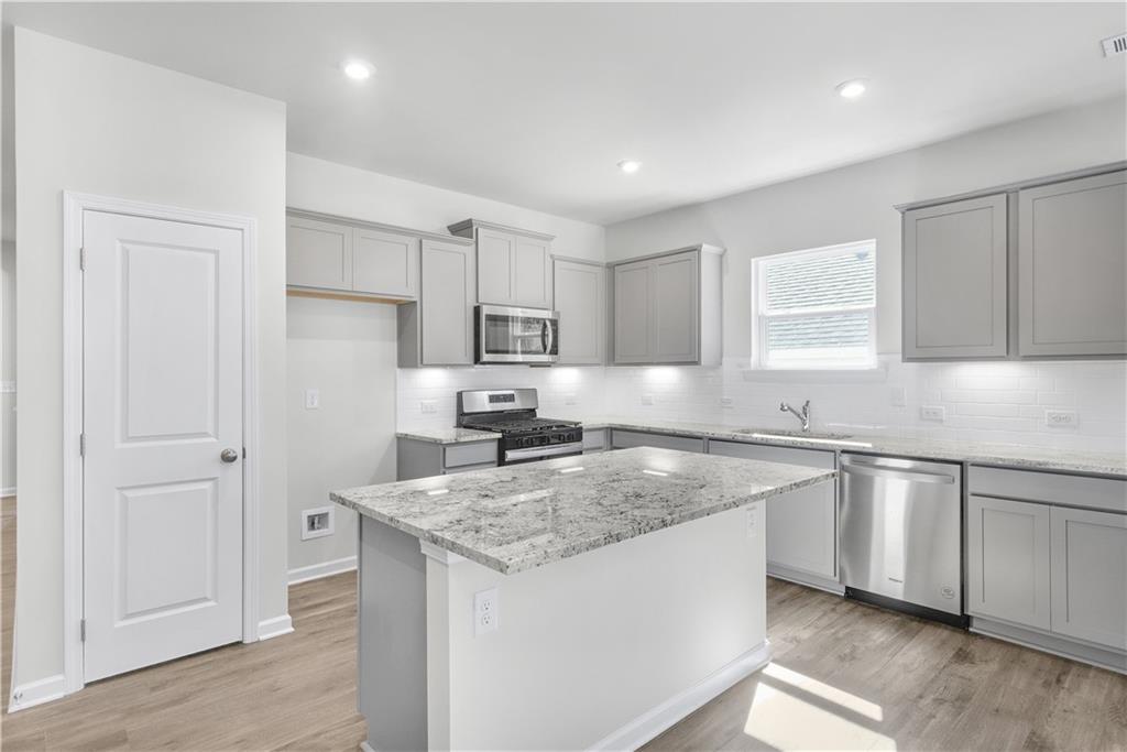 a kitchen with stainless steel appliances granite countertop a sink stove and cabinets