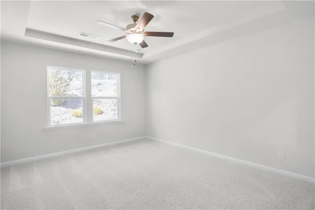 an empty room with a ceiling fan and a window