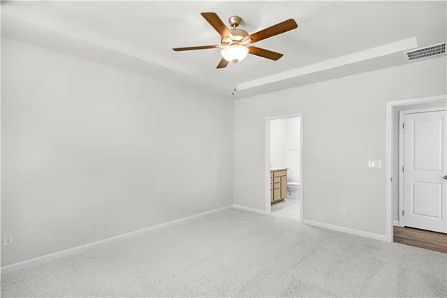 an empty room with closet and a chandelier fan