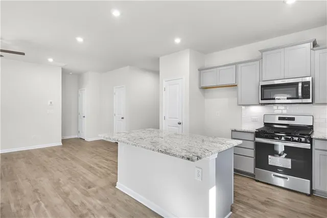 a kitchen with granite countertop a sink cabinets and stainless steel appliances