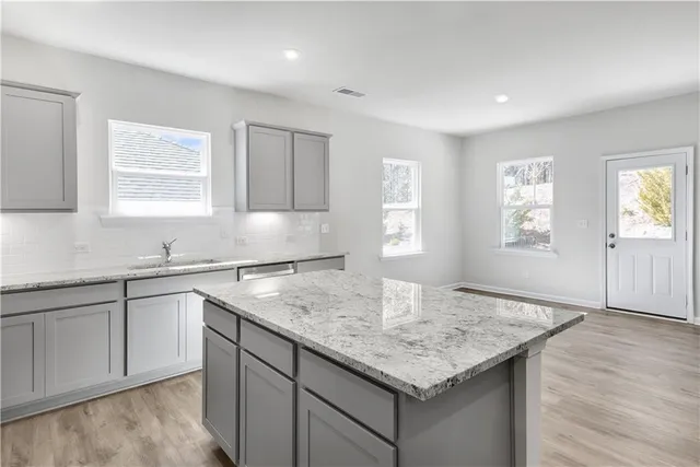 a kitchen with granite countertop sink cabinets and window