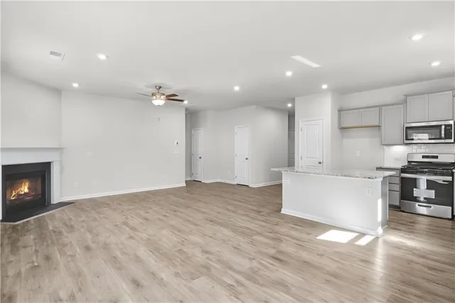 a view of kitchen with kitchen island a sink wooden floor and a stove