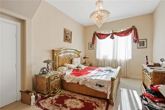a bedroom with a bed and a chandelier