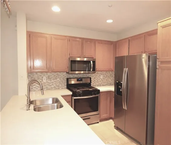 a kitchen with granite countertop a refrigerator and a sink
