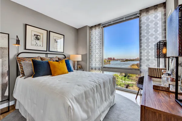 a bed sitting in a bedroom next to a window