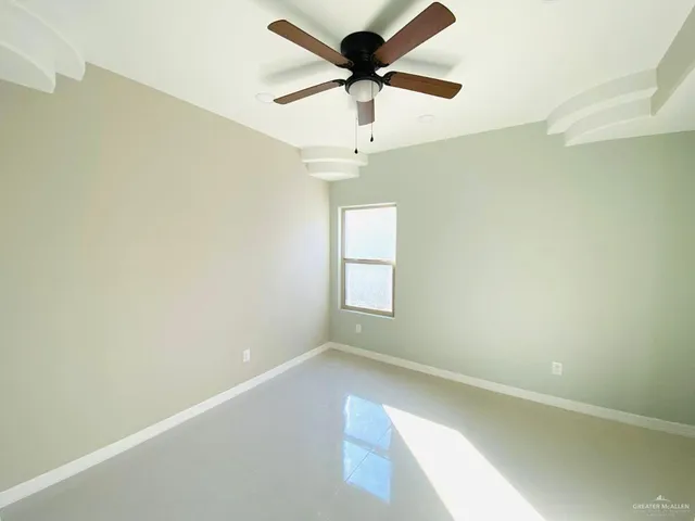 an empty room with a window and a fan