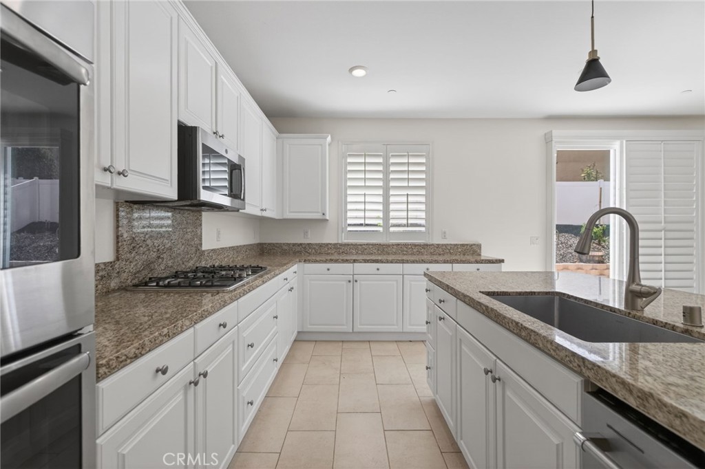 19435 Fortunello Avenue Riverside, CA 92508 - Photo 17 of 51 a kitchen with granite countertop a sink stove and cabinets