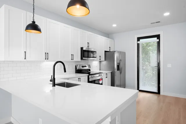 a kitchen with stainless steel appliances a refrigerator sink and microwave