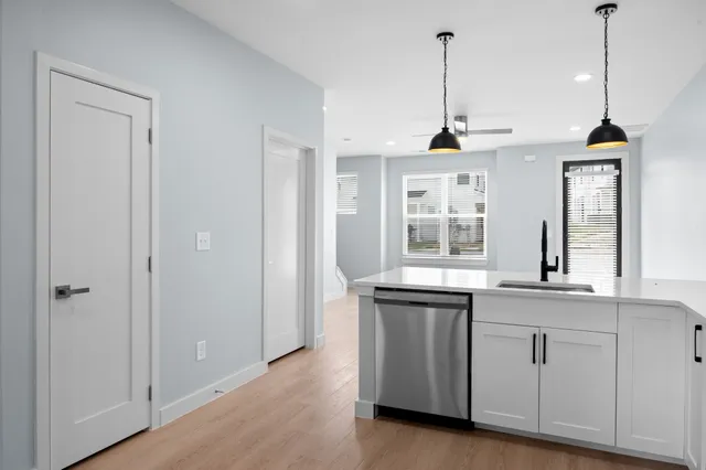 a view of a kitchen with granite countertop stainless steel appliances sink and window