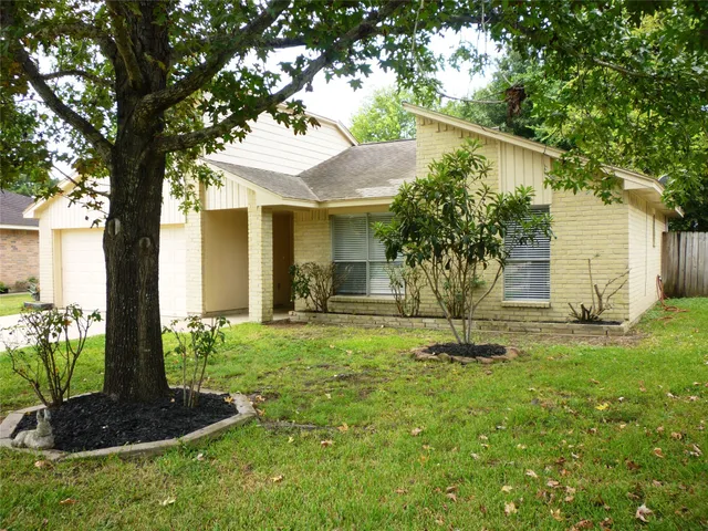 a front view of a house with a yard and tree