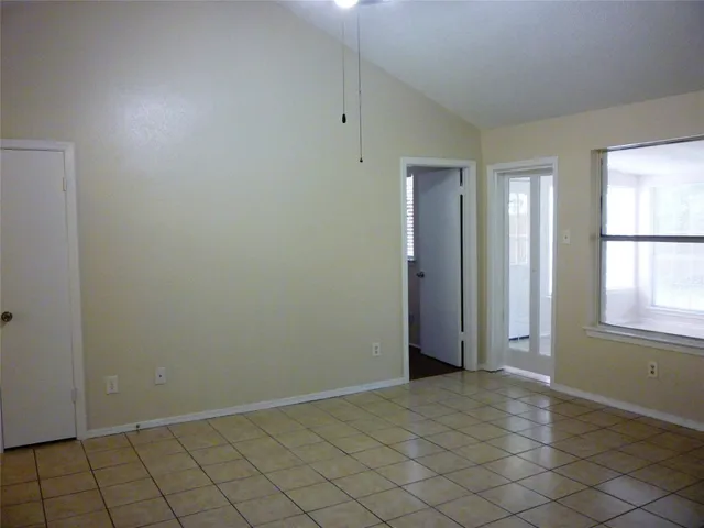 a view of an empty room with wooden floor and a fireplace