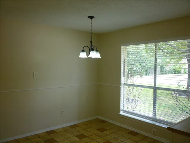 an empty room with a chandelier fan and a chandelier fan