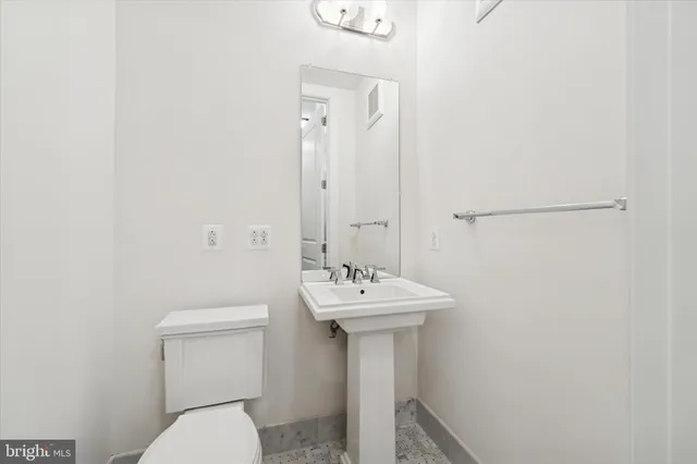 a bathroom with a sink toilet and a mirror