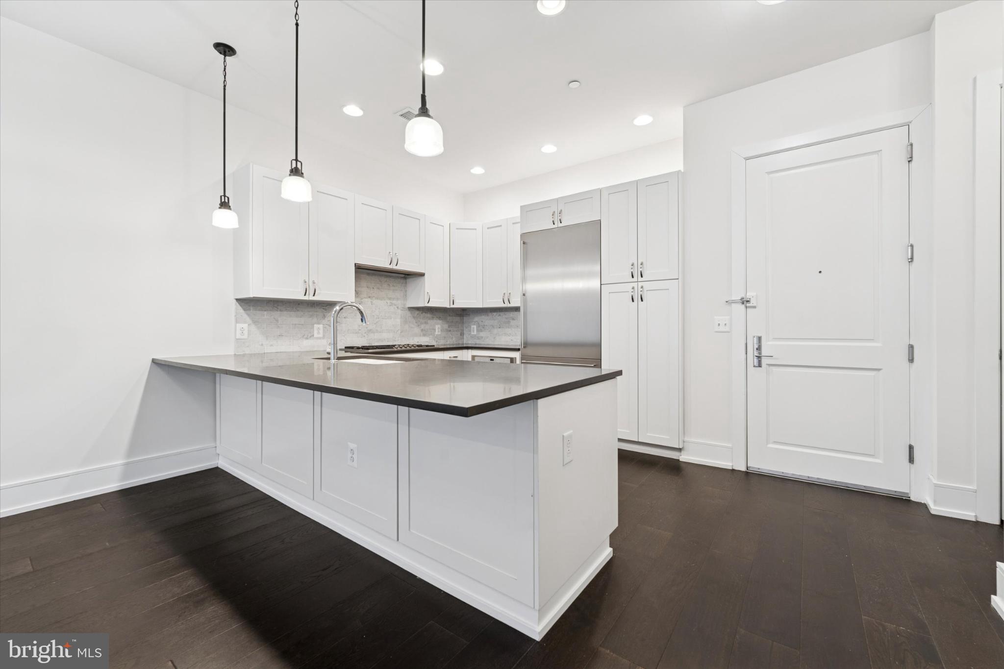 410 South Front Street, Unit 313 Philadelphia, PA 19147 - Photo 4 of 24 a kitchen with kitchen island a sink stainless steel appliances and cabinets