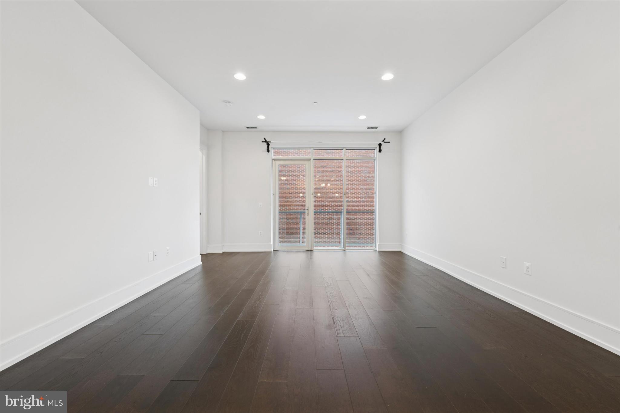 410 South Front Street, Unit 313 Philadelphia, PA 19147 - Photo 8 of 24 an empty room with wooden floor and windows