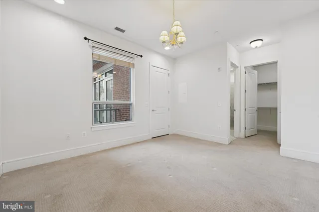 an empty room with a windows and chandelier