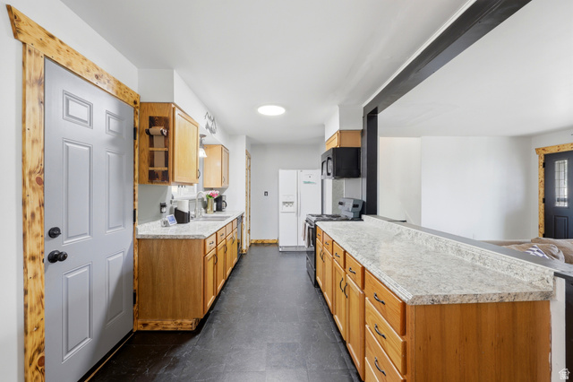 1486 3rd Street Ogden, UT 84404 - Photo 7 of 26 Kitchen featuring wood cabinetry, stone-finish countertops, black appliances, and dark tile flooring