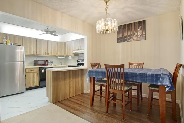 a dining room with stainless steel appliances a table and chairs