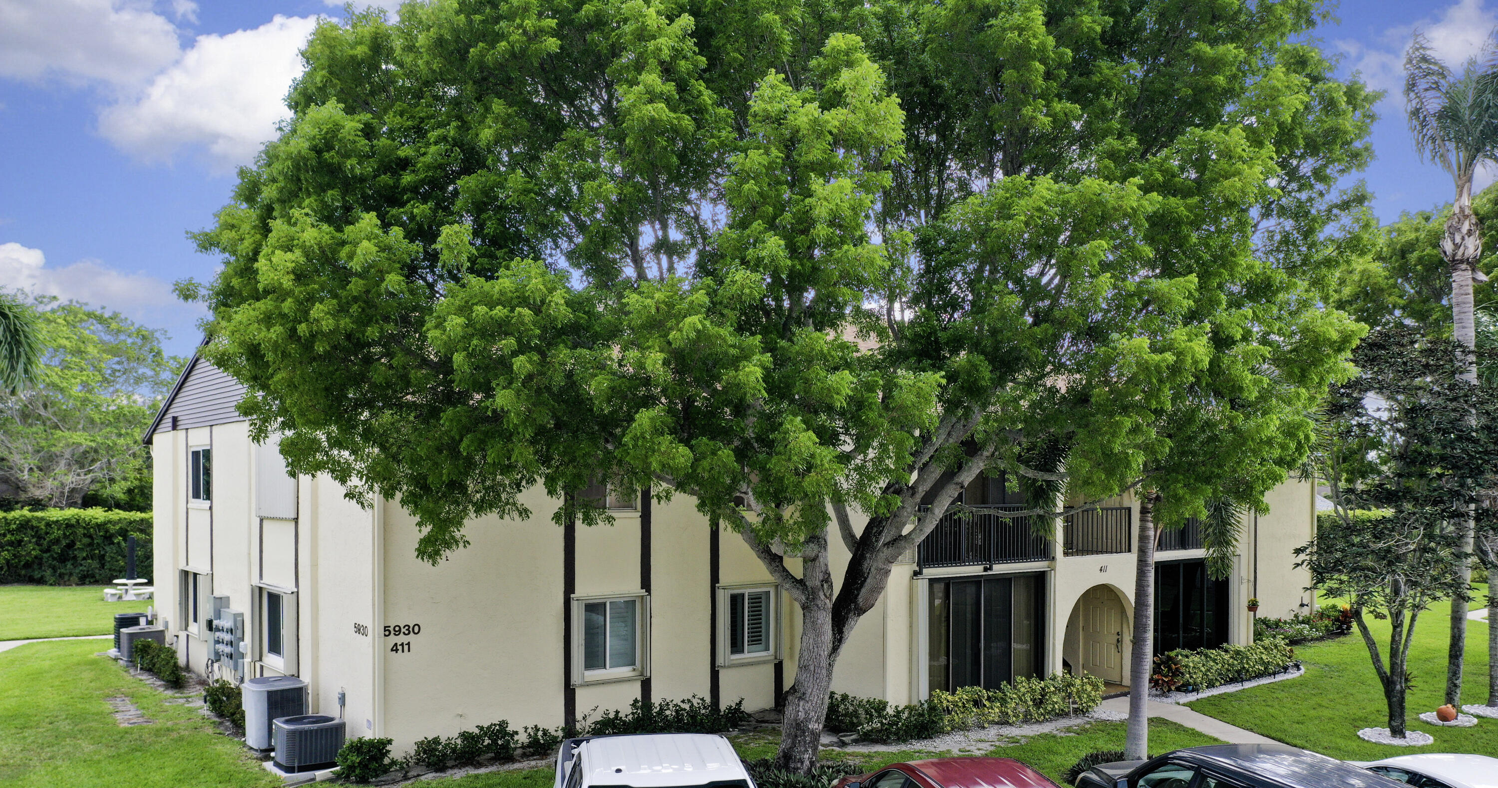 5930 Whispering Pine Way, Unit C2 Greenacres, FL 33463 - Photo 16 of 20 a front view of a house with garden