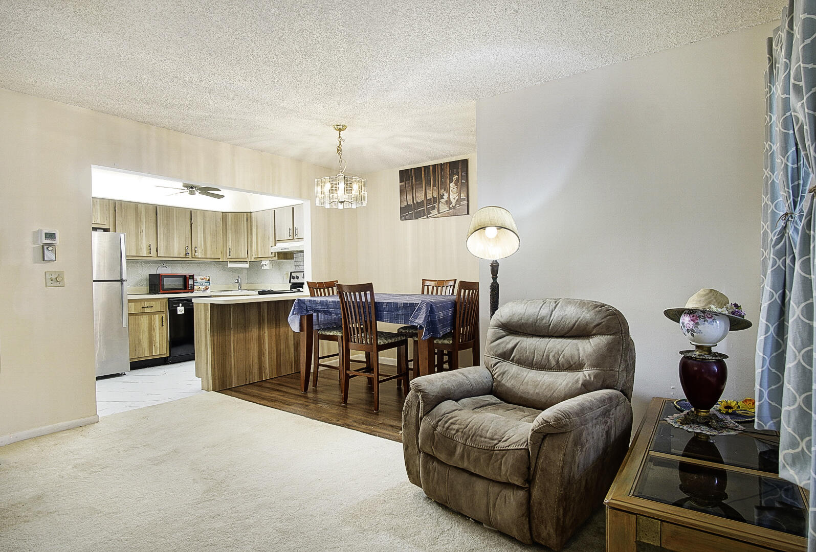 5930 Whispering Pine Way, Unit C2 Greenacres, FL 33463 - Photo 4 of 20 a living room with furniture a chandelier and kitchen view