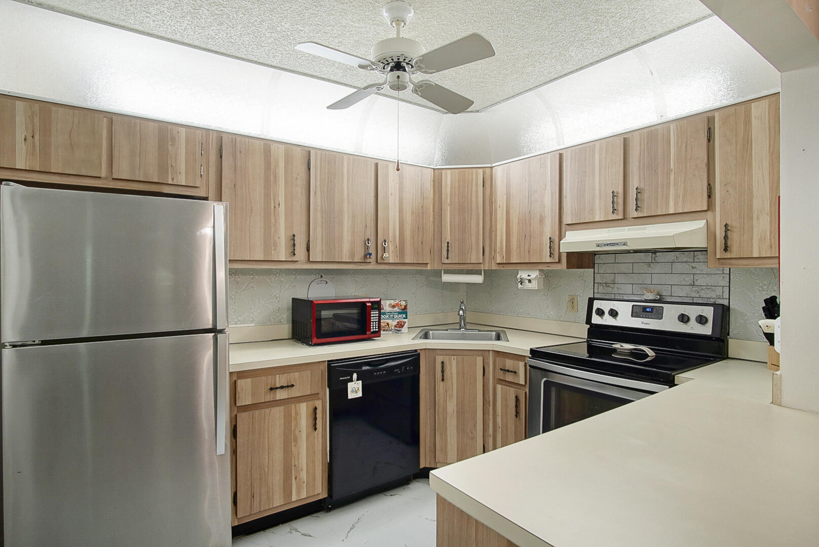 5930 Whispering Pine Way, Unit C2 Greenacres, FL 33463 - Photo 7 of 20 a kitchen with kitchen island a sink stainless steel appliances and cabinets