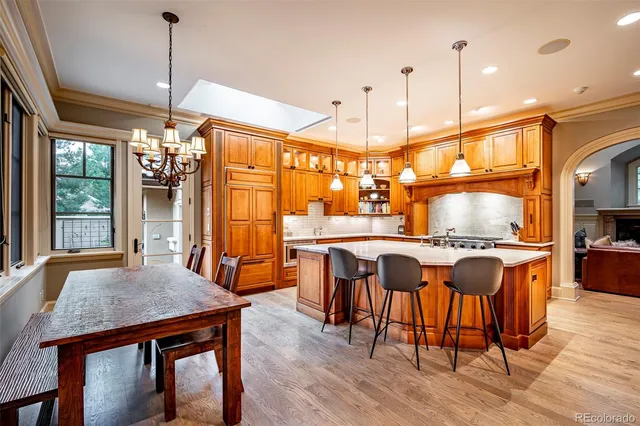 a kitchen with kitchen island granite countertop a stove a sink a refrigerator and wooden cabinets