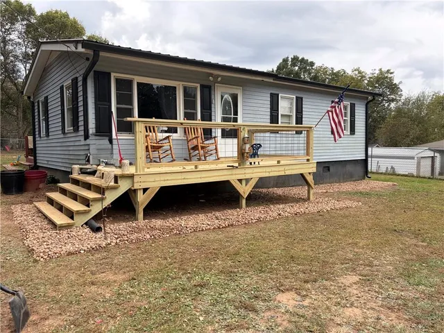 a view of a house with backyard and sitting area