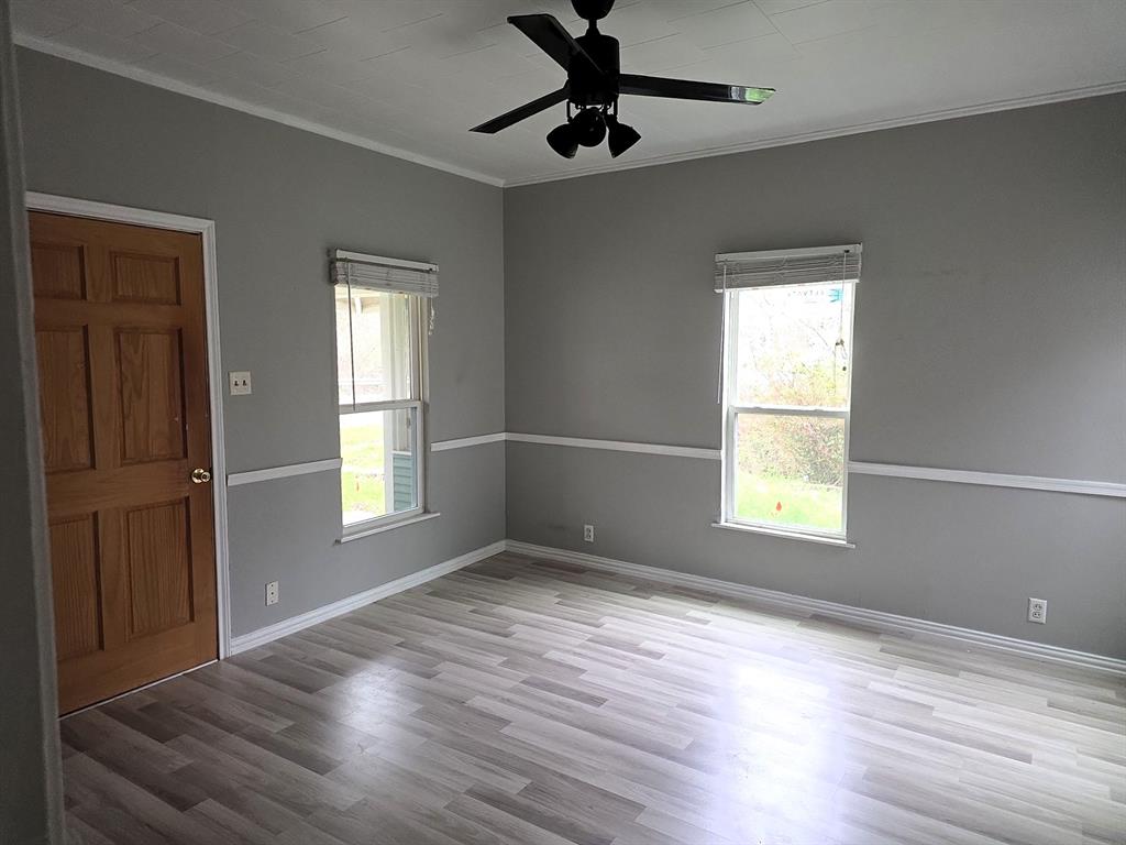 612 North Adelaide Street Terrell, TX 75160 - Photo 8 of 11 a view of an empty room with wooden floor and a window