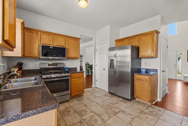 a kitchen with stainless steel appliances granite countertop a refrigerator stove and sink