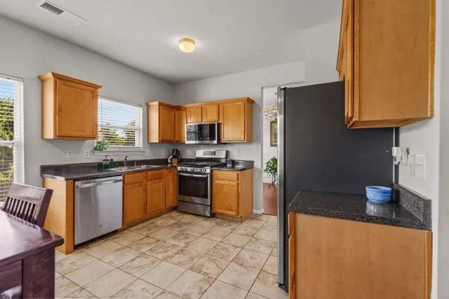 a kitchen with stainless steel appliances granite countertop a stove a sink and a refrigerator