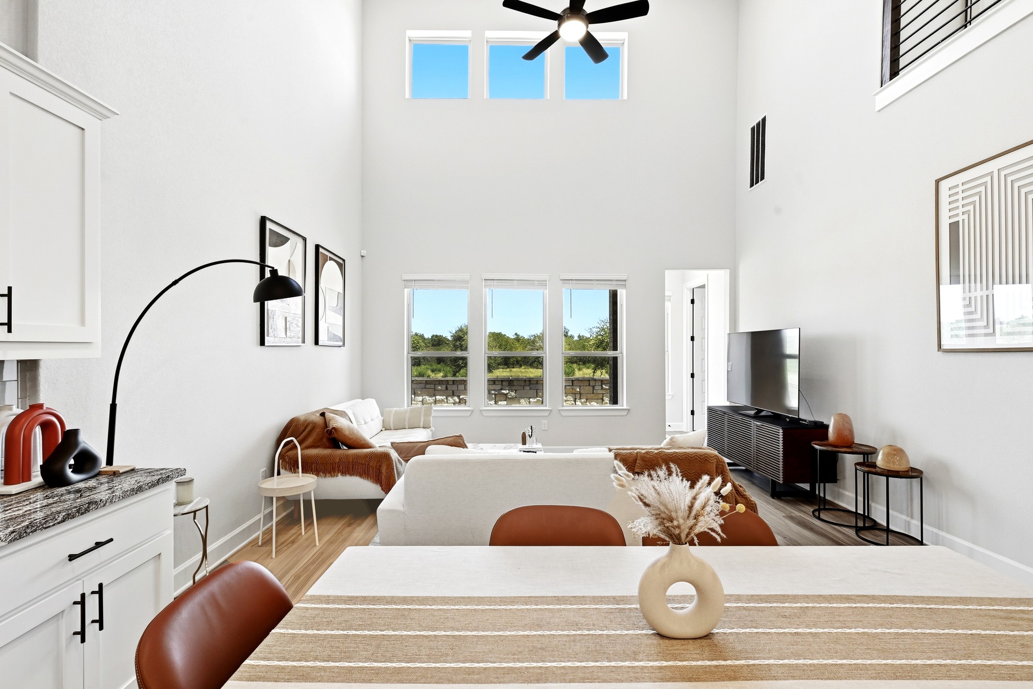 2702 Sebring Circle Austin, TX 78747 - Photo 9 of 35 Double-height ceilings and tall windows illuminate this spacious open living area.