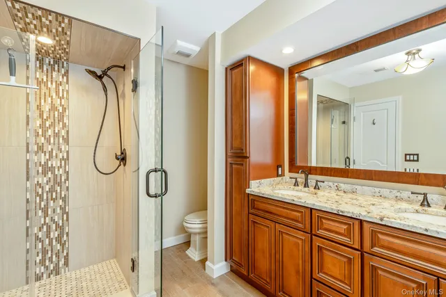 a bathroom with a granite countertop sink toilet and shower