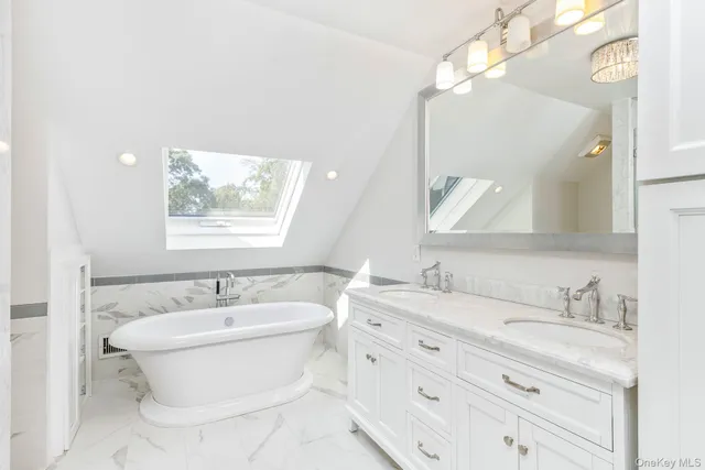 a bathroom with a double vanity sink mirror and bathtub