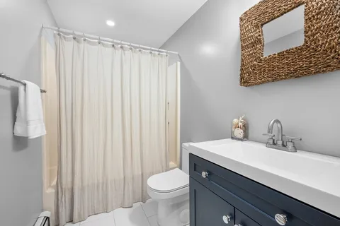a bathroom with a sink a toilet and shower curtain