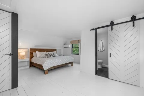 a bedroom with a bed and a night stand