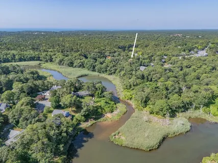 an aerial view of a house with a yard and lake view