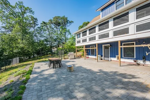 a front view of a building with garden and bench