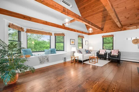 a living room with patio furniture and a large window