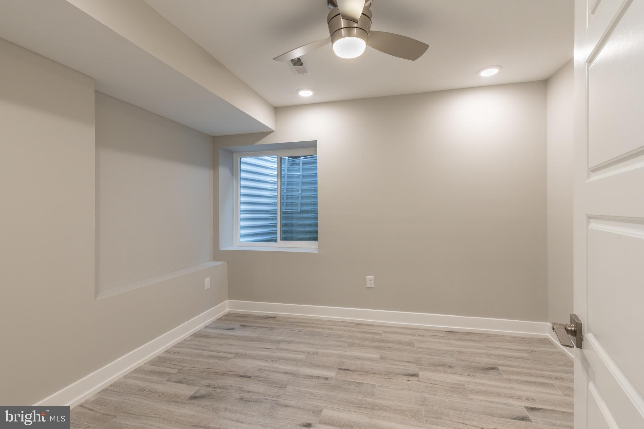 135 West Huntingdon Street, Unit 1 Philadelphia, PA 19133 - Photo 14 of 29 an empty room with wooden floor and windows